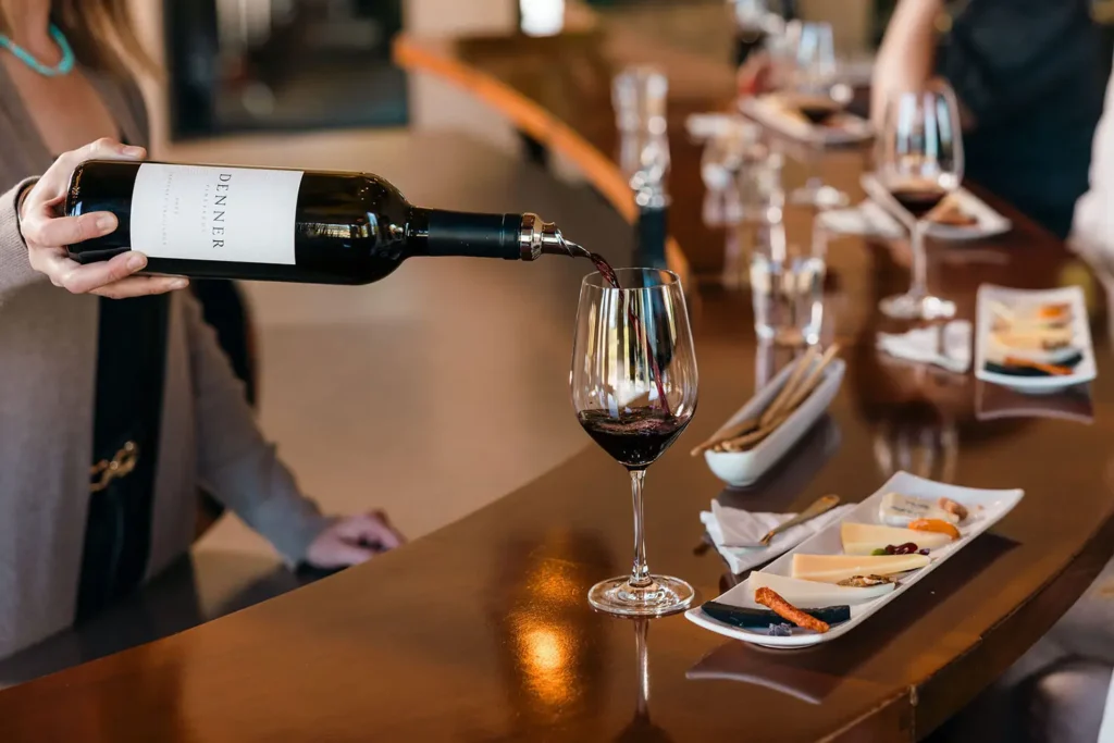 Person pouring wine at a Cheese and Wine Tasting at Denner Vineyards.