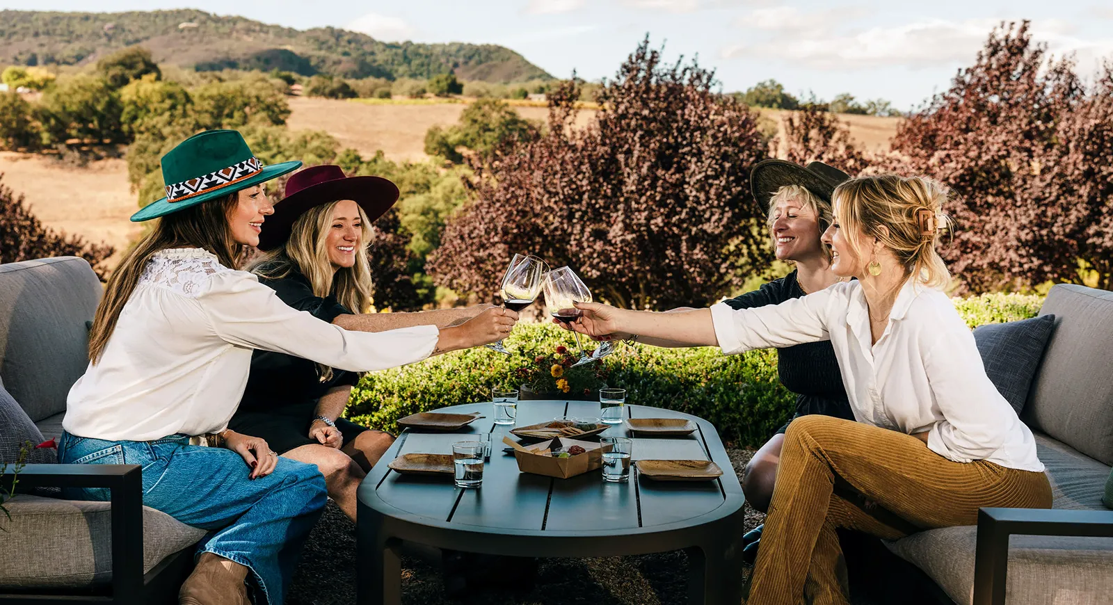 Four friends raising their glasses to cheers with Denner wines.