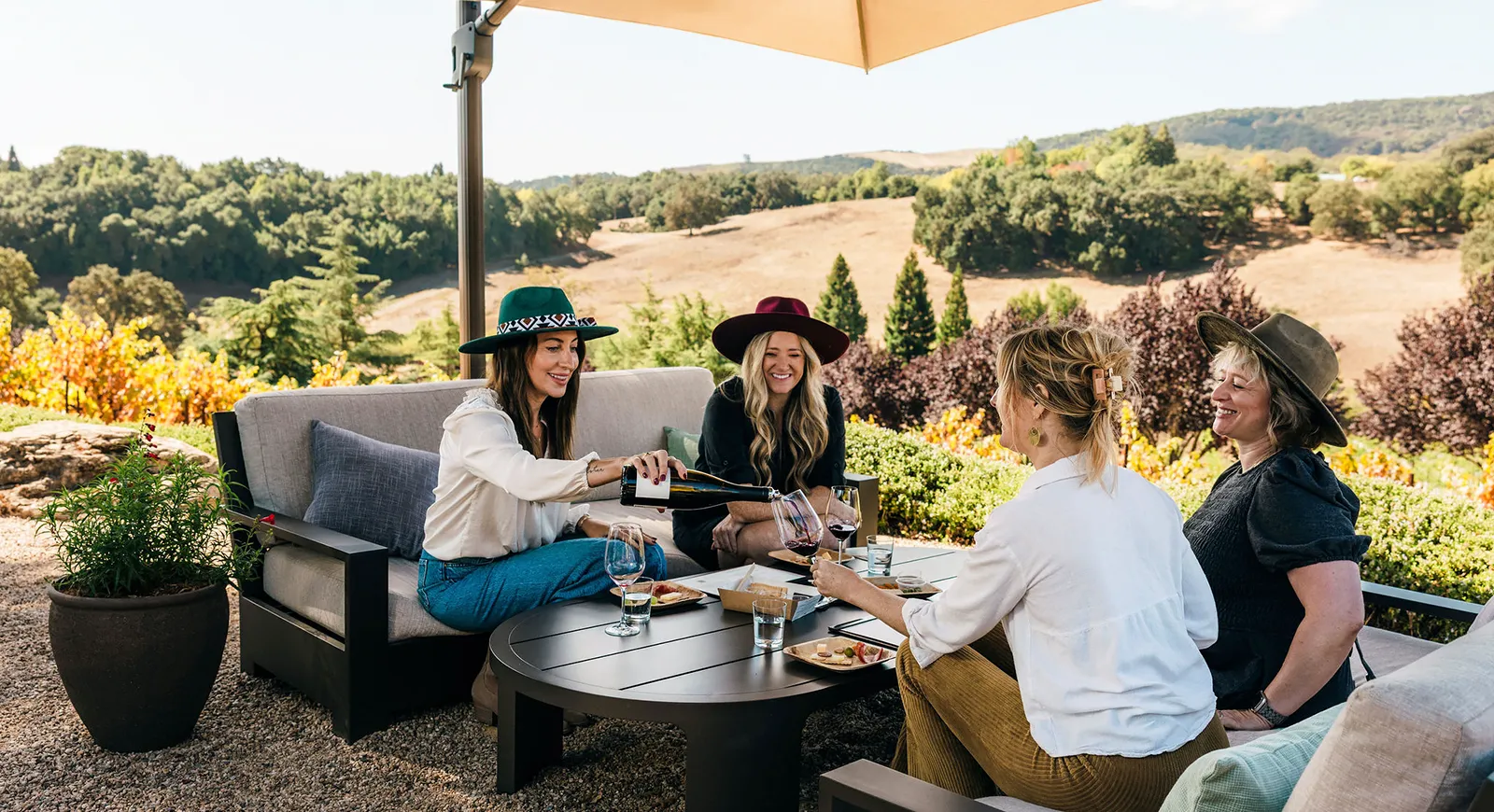 Four friends sit outside Denner Vineyards enjoying Denner wines.